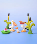 Bumbu Toys Eating Pelican, Pelican Chick and Pelican, all in a scene with Bumbu Cattails and Lilypads