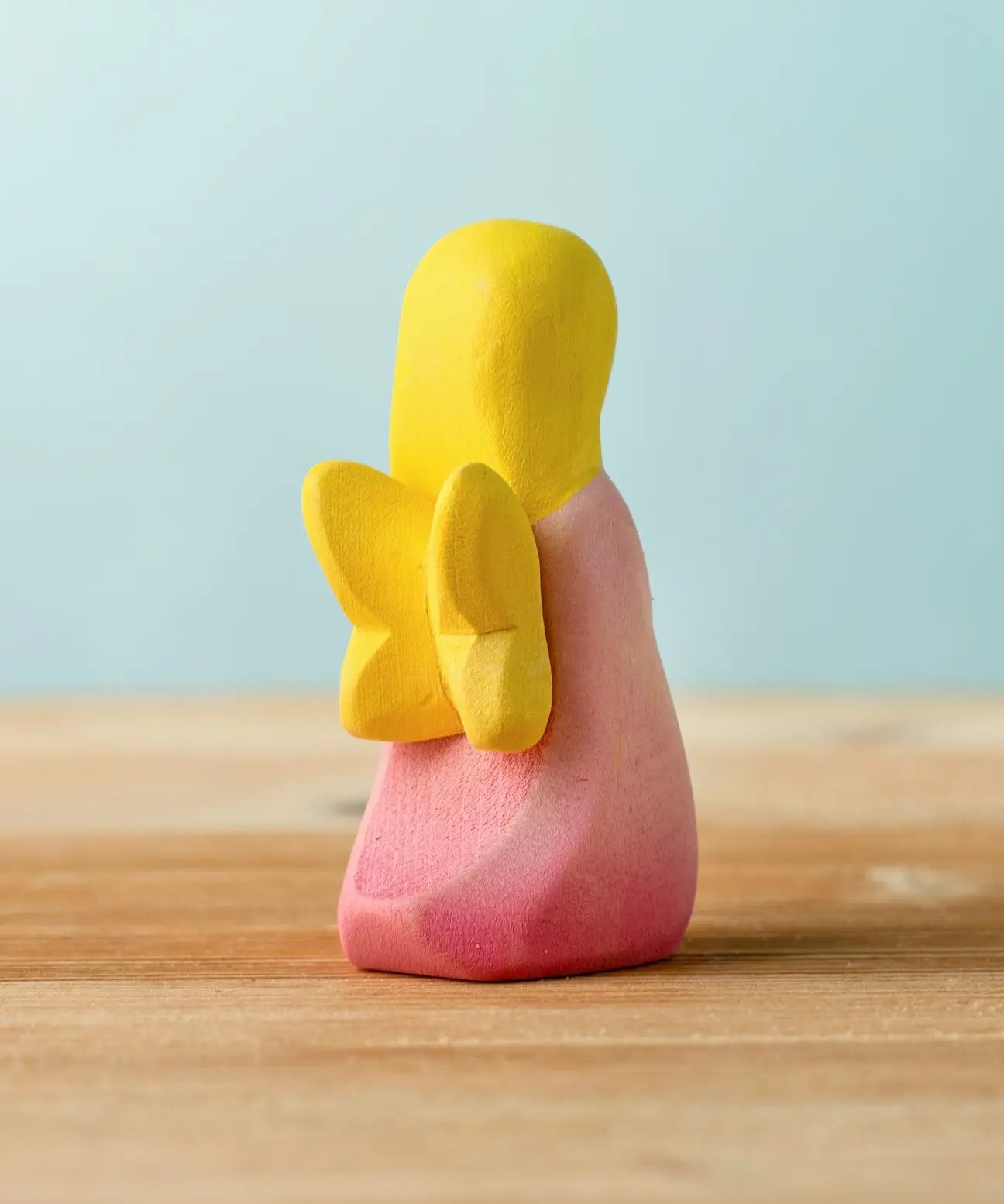 Back of the Bumbu wooden pink fairy figure showing yellow wings detail