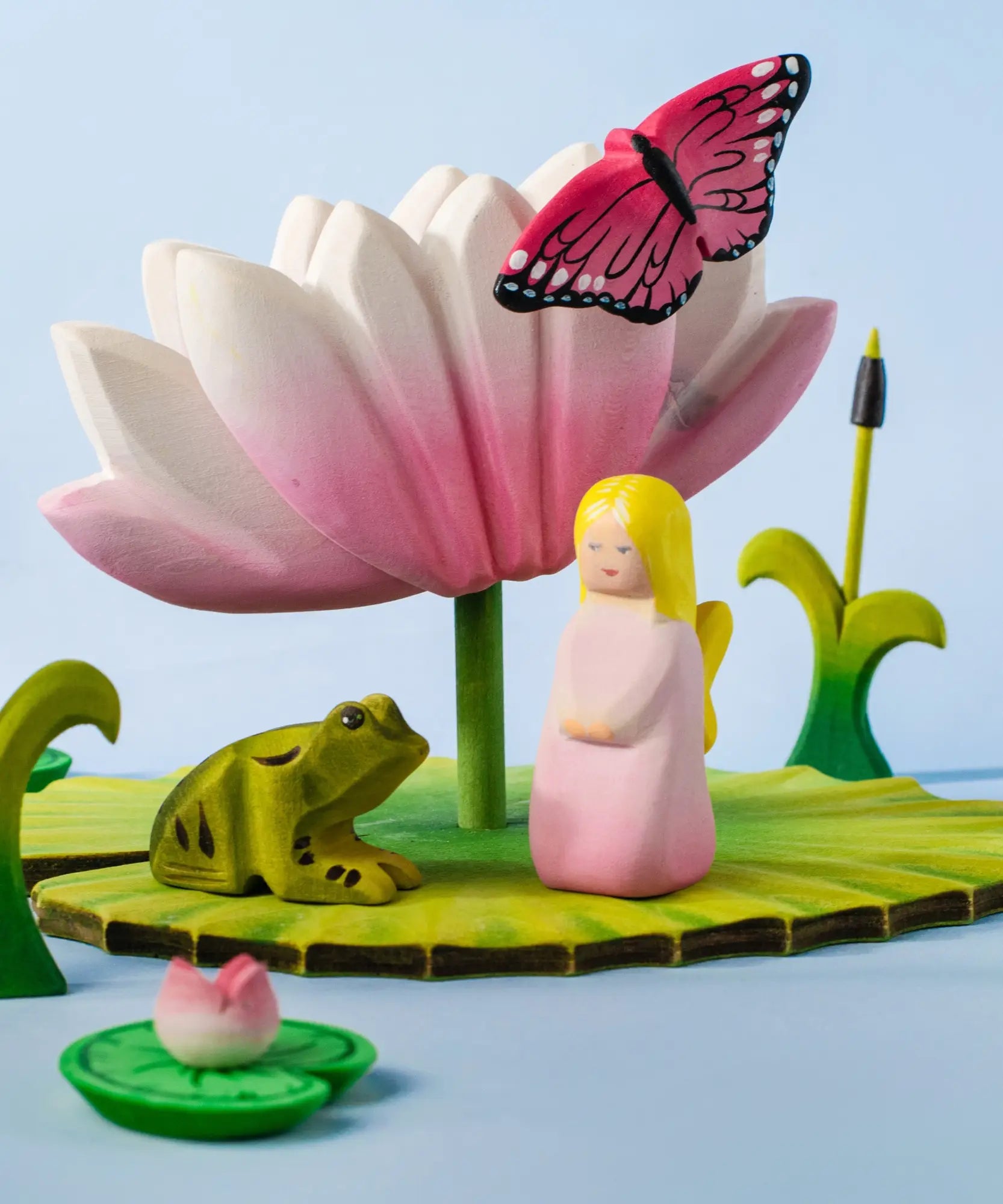 A pond playscene showing a Bumbu pink fairy figure, frog, butterfly, lily and lotus flower figures
