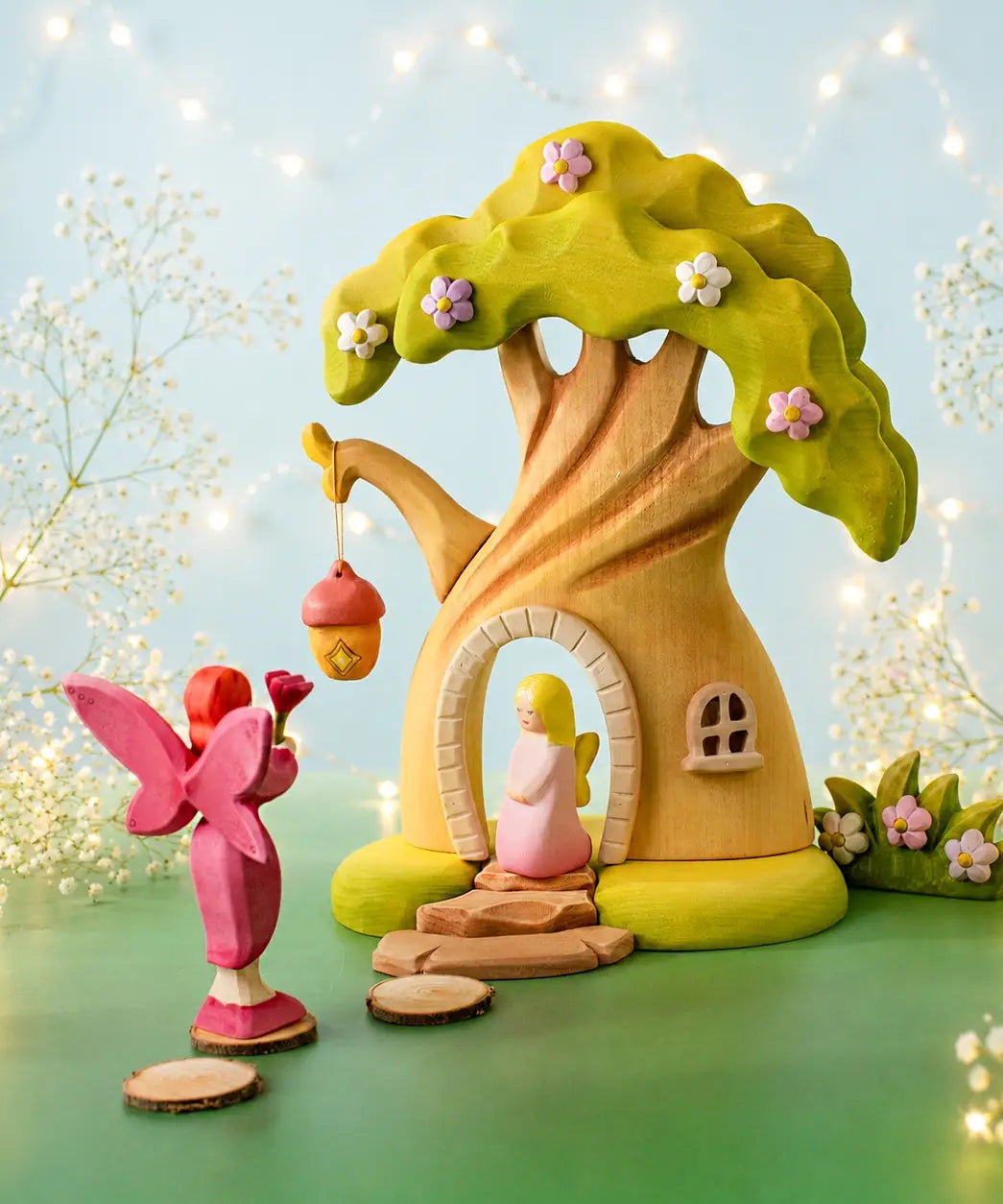 Bumbu handcrafted wooden pink fairy figure standing in the fairy treehouse doorway