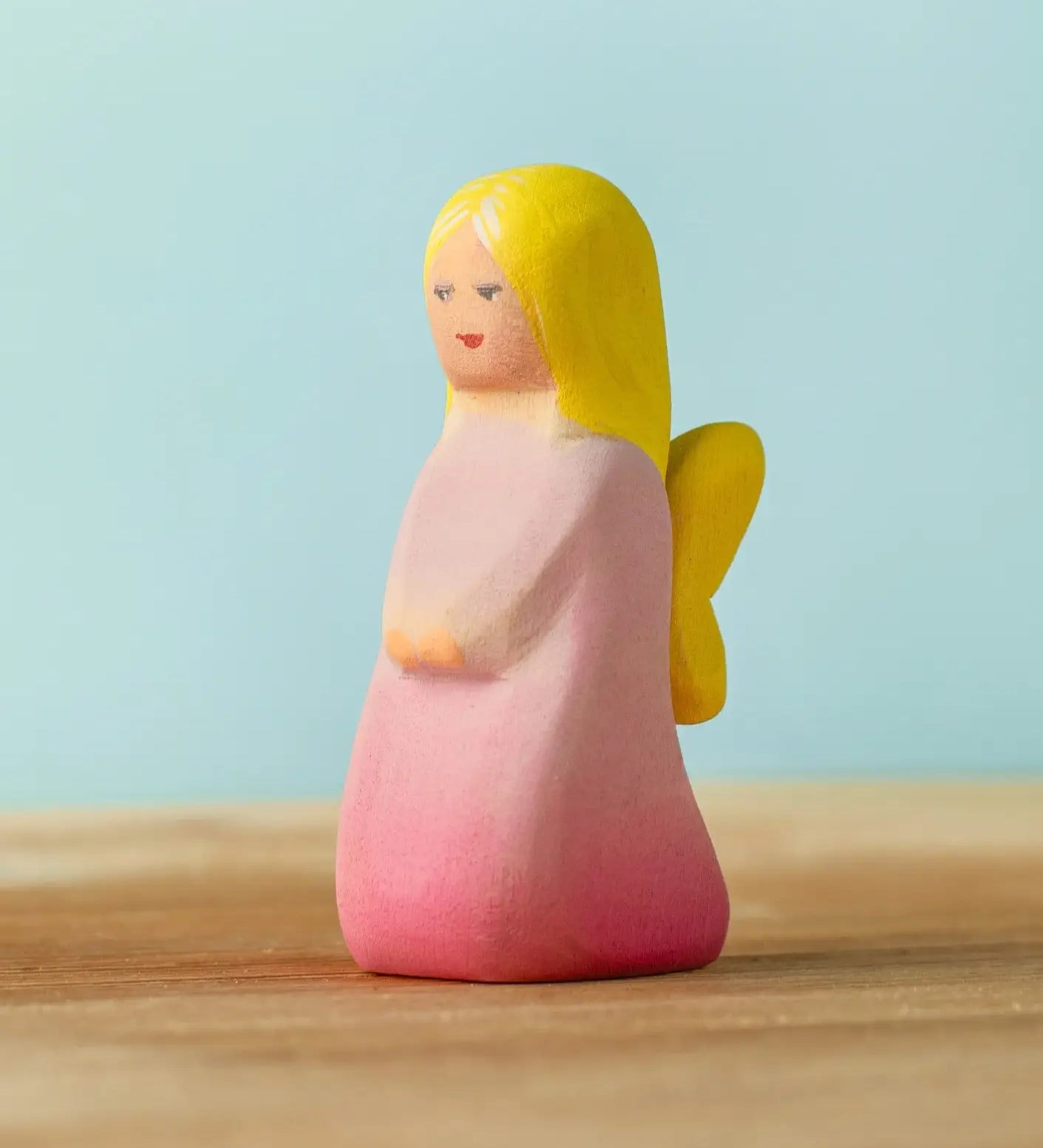Bumbu handcrafted wooden pink fairy figure with painted yellow hair and facial features