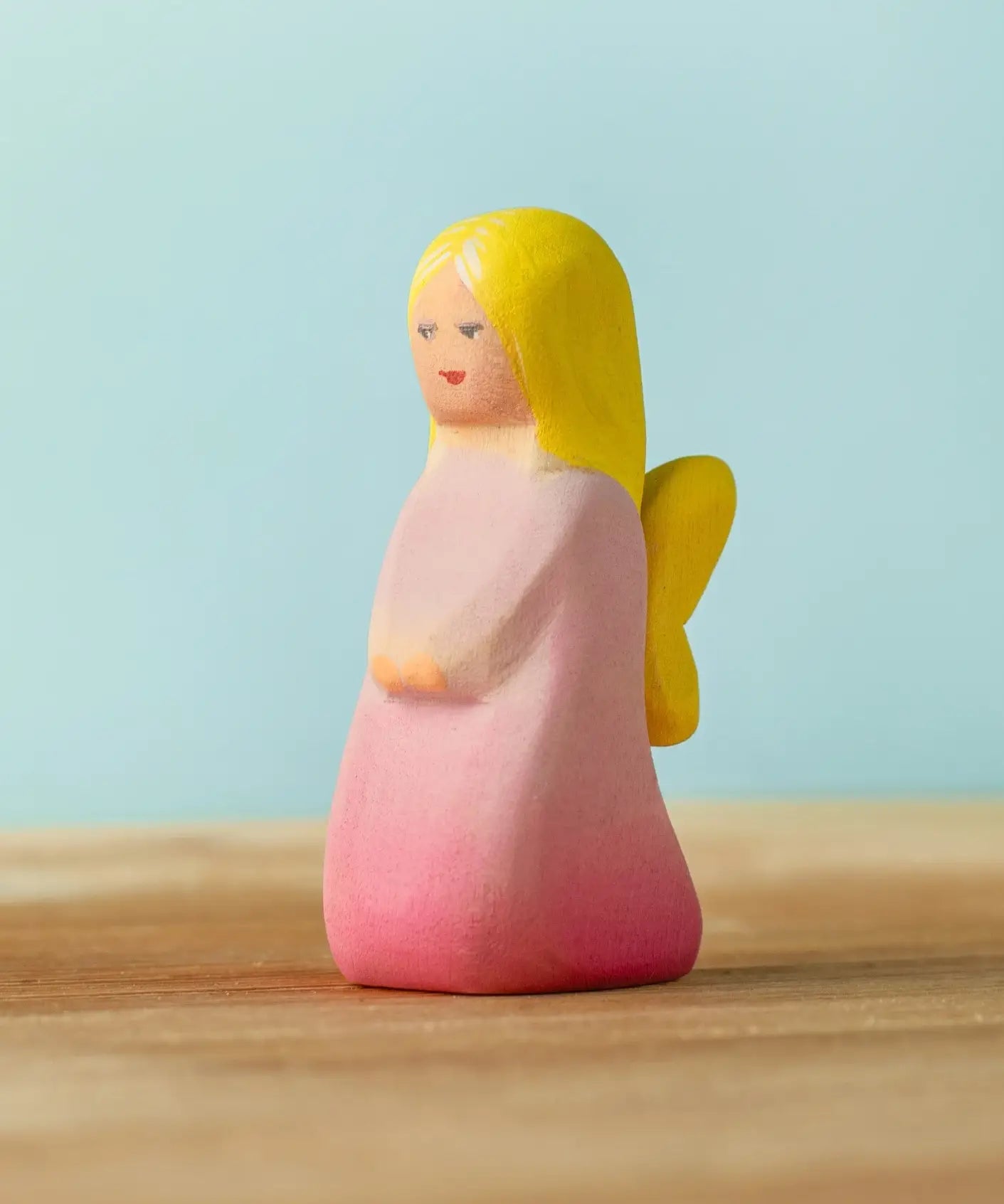 Bumbu handcrafted wooden pink fairy figure with painted yellow hair and facial features