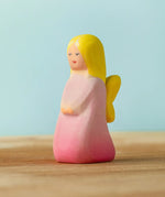 Bumbu handcrafted wooden pink fairy figure with painted yellow hair and facial features