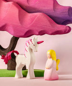 Bumbu wooden pink fairy figure next to a pink unicorn and blossom tree figure