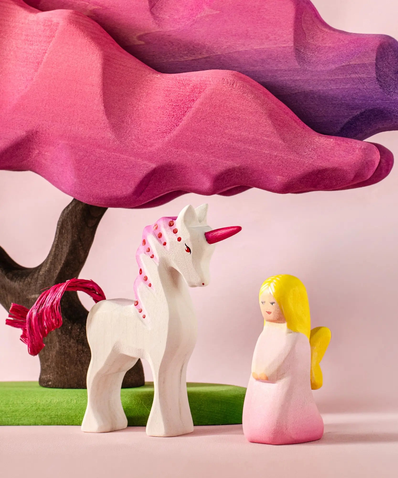 Bumbu wooden pink fairy figure next to a pink unicorn and blossom tree figure