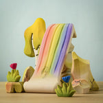 The Bumbu rainbow waterfall shown in a small world play scene with the rainbow rocks and Bumbu flowers and a birch tree. 