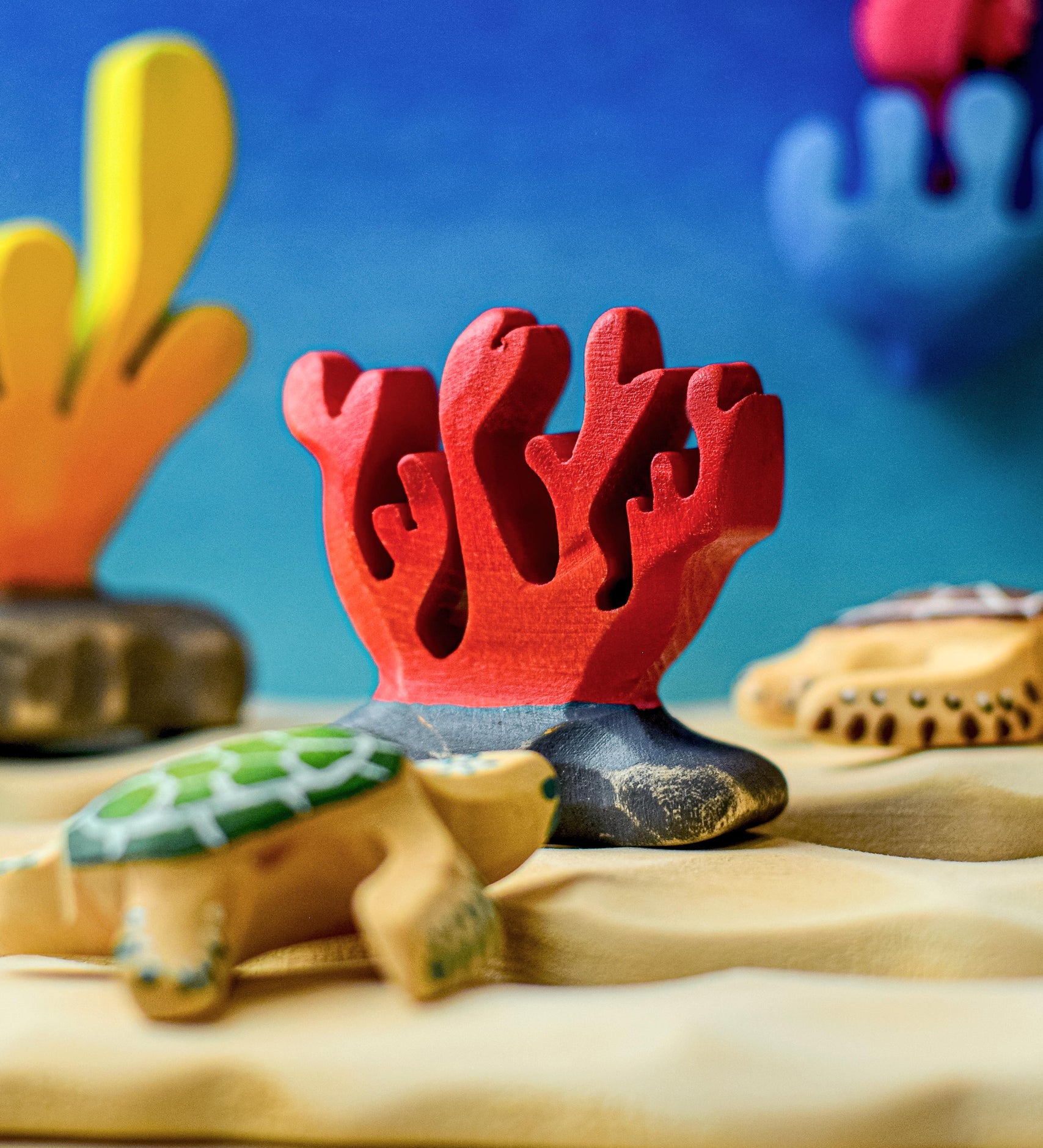 A red Bumbu wooden coral figure set up in an ocean themed small world play.
