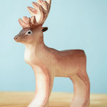 Bumbu Toys Reindeer figure placed on a wooden surface. 