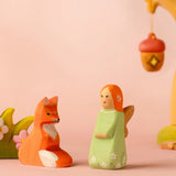 Bumbu wooden sage fairy figure standing next to a sitting fox figure
