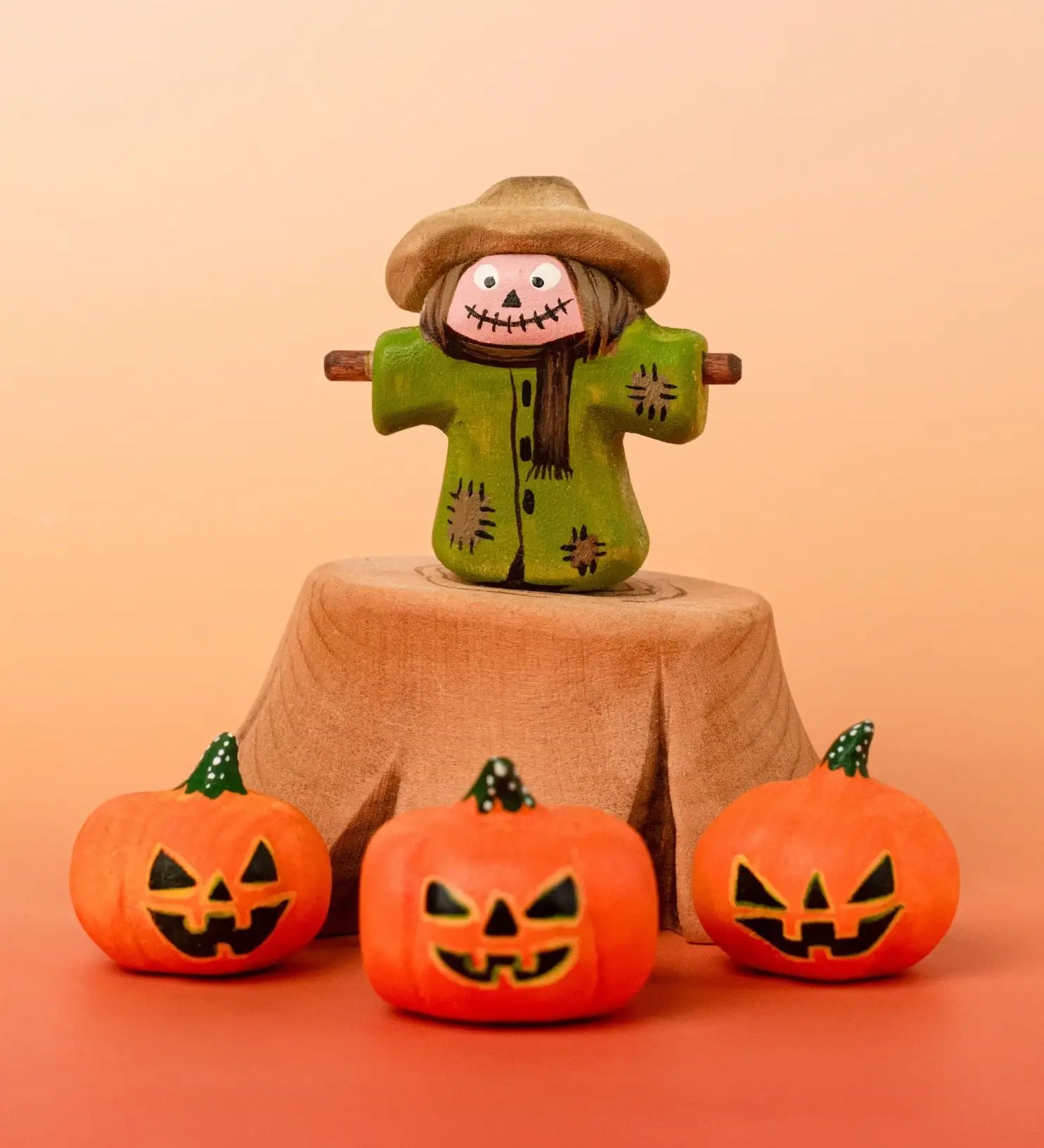 Bumbu handcrafted wooden scarecrow decorative figure in a spooky display including a tree stump and mini pumpkin figures