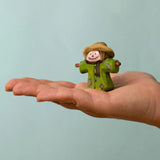 Bumbu handcrafted wooden scarecrow decorative figure on an adult hand showing scale