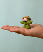 Bumbu handcrafted wooden scarecrow decorative figure on an adult hand showing scale