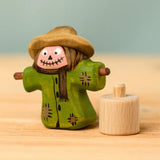 Bumbu handcrafted wooden scarecrow decorative figure next to a celebration ring peg base
