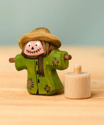 Bumbu handcrafted wooden scarecrow decorative figure next to a celebration ring peg base