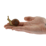 Side view of the Bumbu wooden snail figure on a plain background 