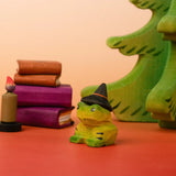 Bumbu handcrafted wooden spell green frog decorative figure in a spooky scene including spell books, trees and a candle figure