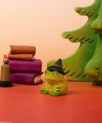 Bumbu handcrafted wooden spell green frog decorative figure in a spooky scene including spell books, trees and a candle figure