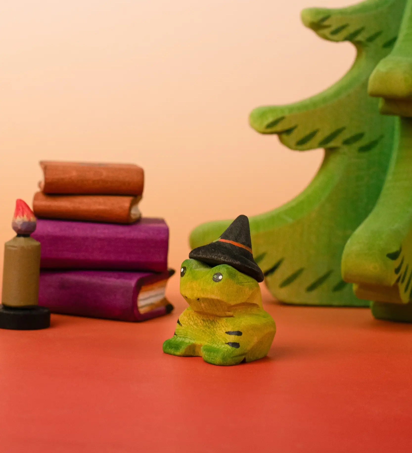 Bumbu handcrafted wooden spell green frog decorative figure in a spooky scene including spell books, trees and a candle figure