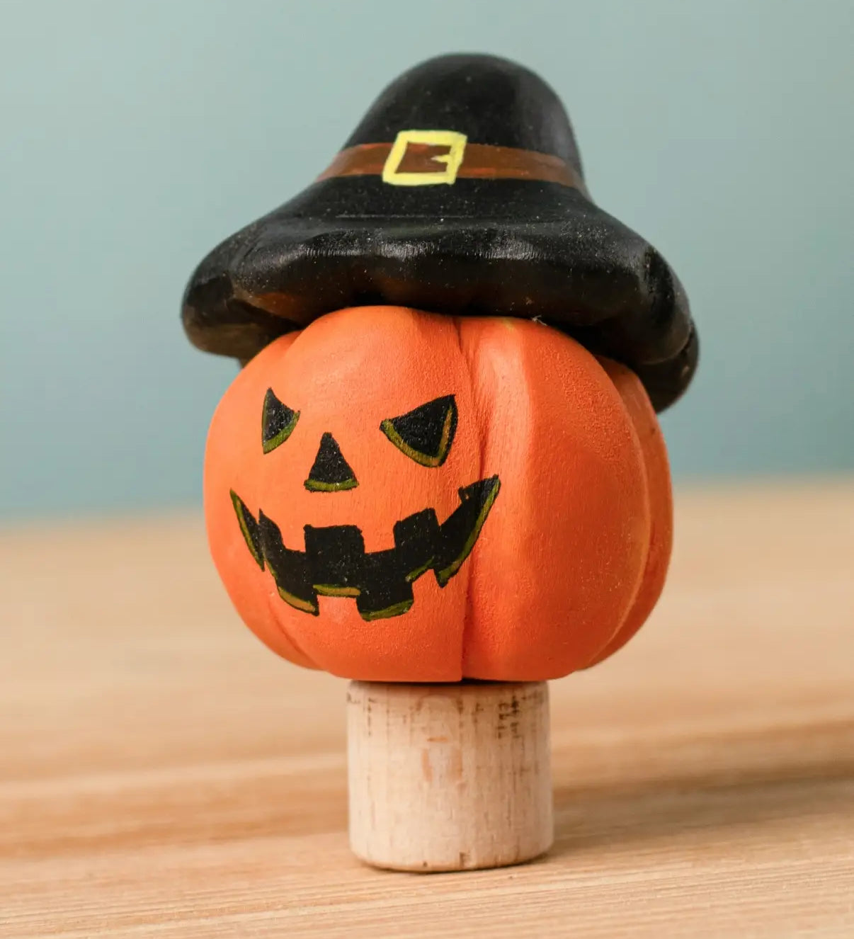 Bumbu handcrafted wooden magic pumpkin decorative figure wearing a black hat.