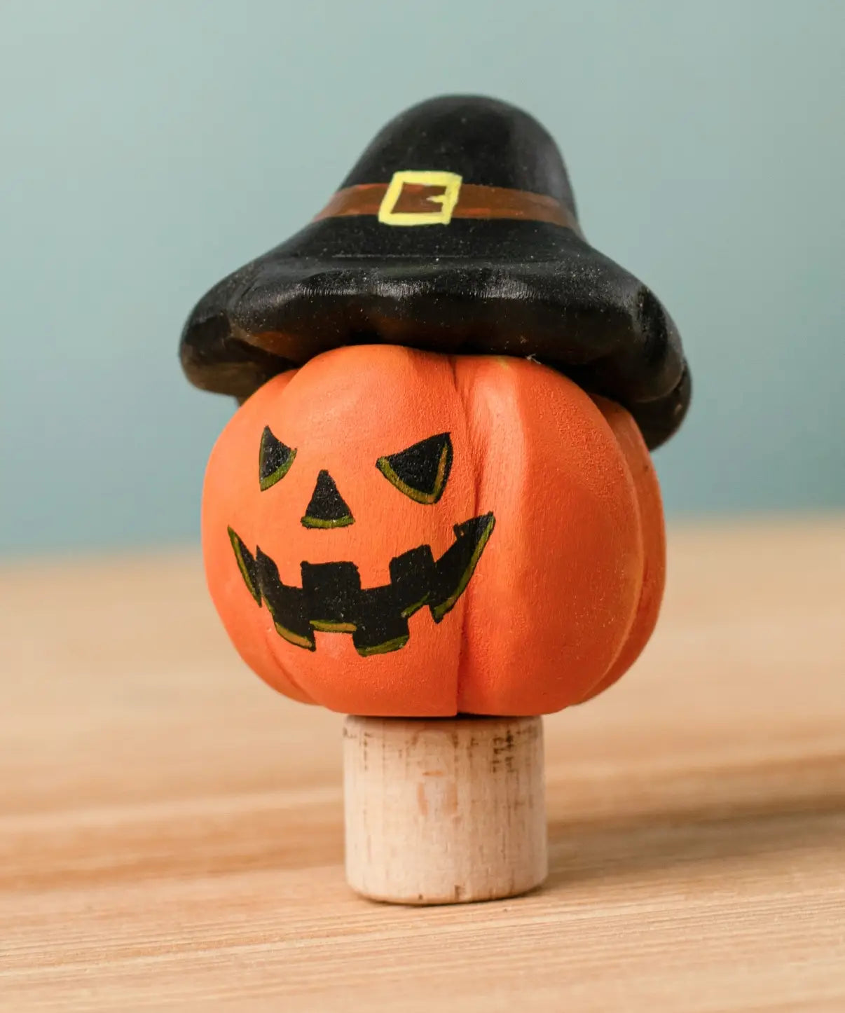 Bumbu handcrafted wooden magic pumpkin decorative figure wearing a black hat.