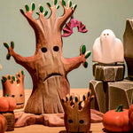 A Bumbu spooky tree set up in a small world play scene with a wooden Bumbu bat hung on one of it's branches. 