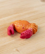 The Bumbu hand carved wooden red crab toy, with white speckled details on its shell