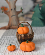 Three Bumbu pumpkins, small, medium and large. The medium pumpkin has been placed in a Kraul basket with the two others placed besides it. 