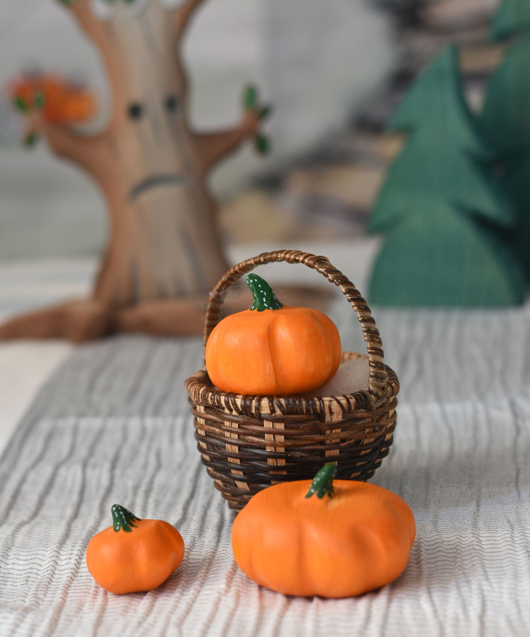 Three Bumbu pumpkins, small, medium and large. The medium pumpkin has been placed in a Kraul basket with the two others placed besides it. 