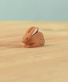 The Bumbu Toys wooden baby brown rabbit, sat in a perching position