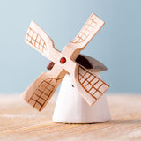 Bumbu Miniature Wooden Moldova Windmill. The toy sits on a wooden surface against a blue background.