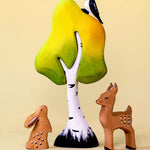 A small wooden Bumbu tree with a rabbit and fawn stood underneath. A wooden woodpecker is perched on top. 