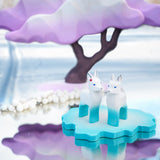Two Bumbu wooden winter fawn figures stood on a Bumbu ice floe next to a winter maple tree toy