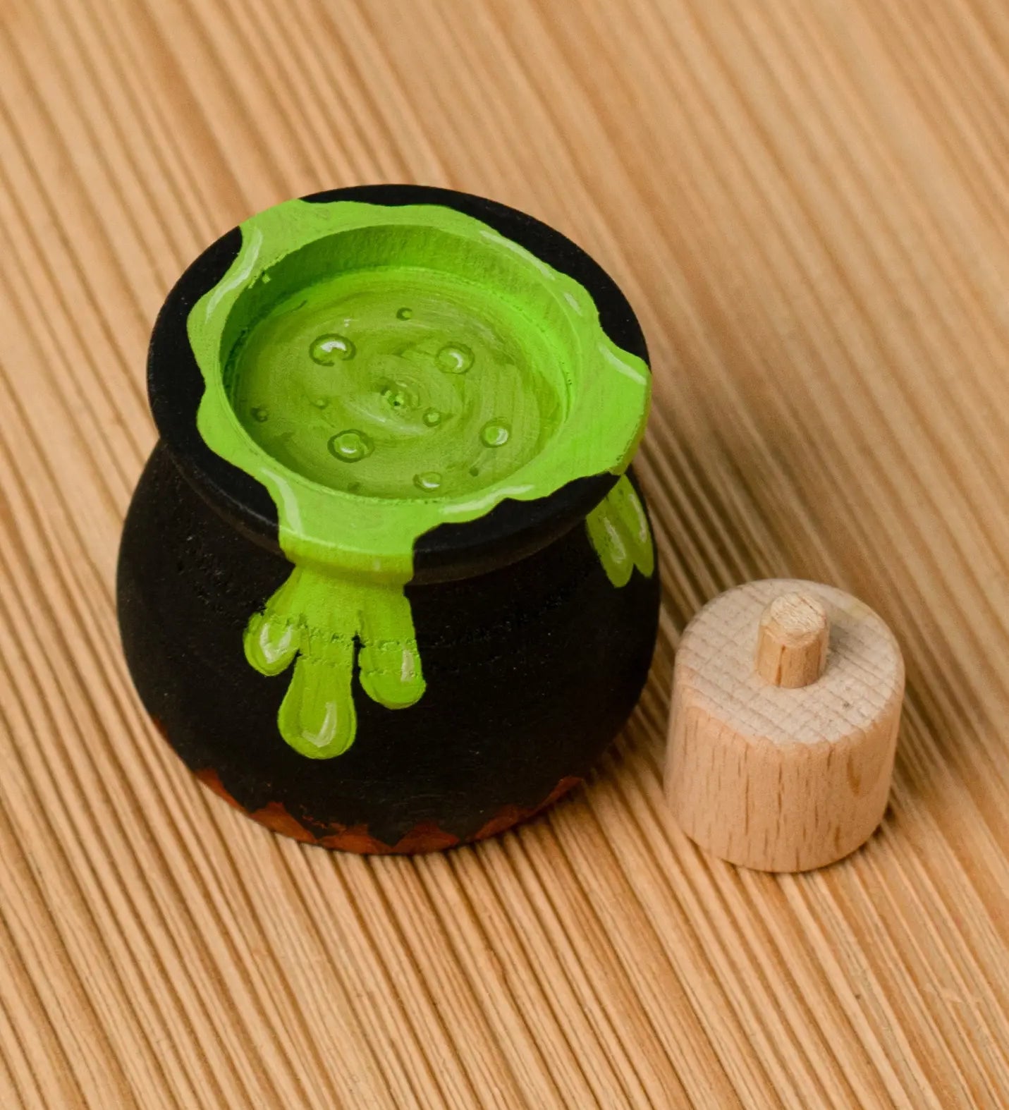 Bumbu handcrafted wooden black magic cauldron decorative figure showing the painted green potion inside