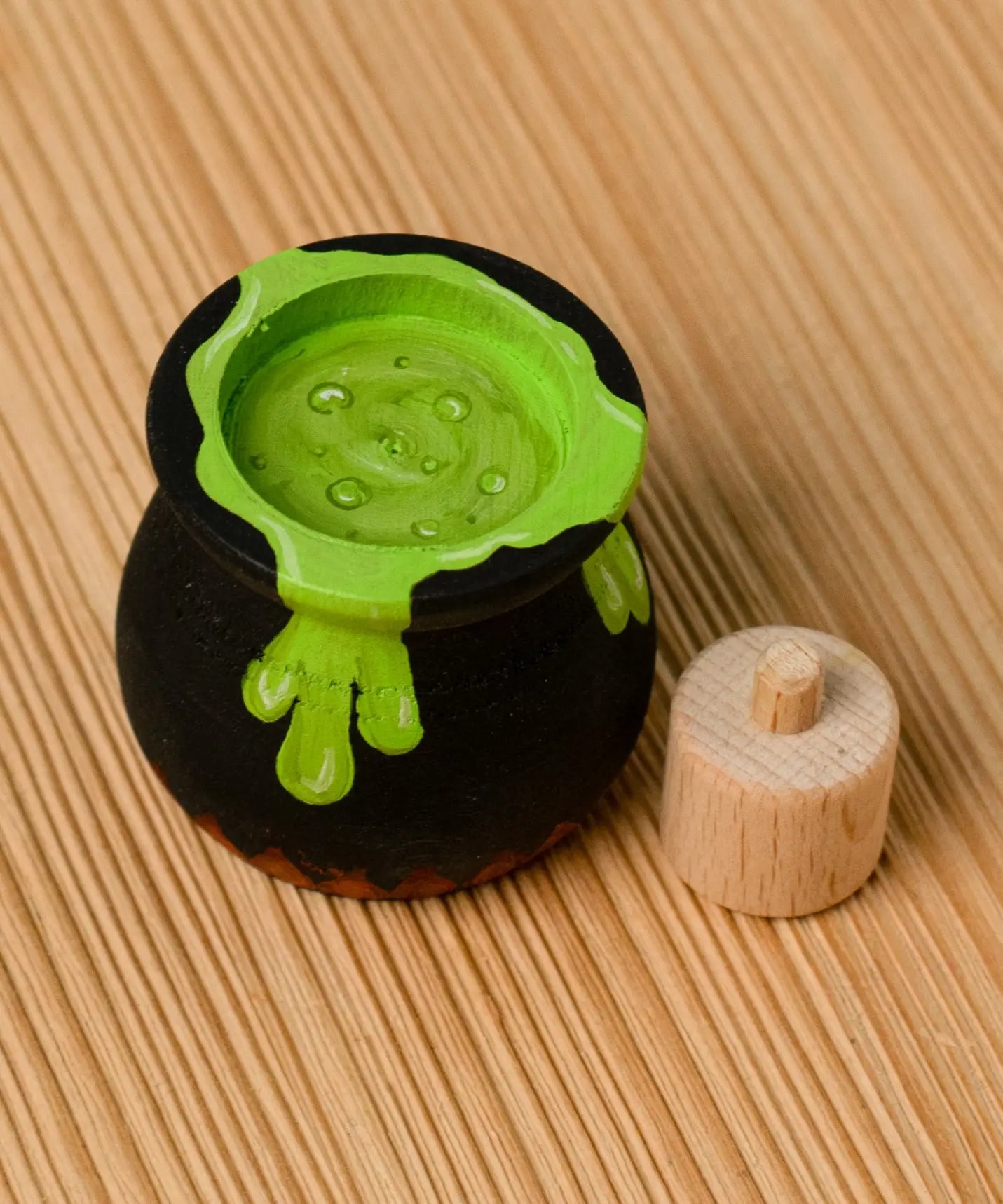 Bumbu handcrafted wooden black magic cauldron decorative figure showing the painted green potion inside