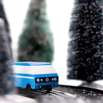 CandyLab blue VW T3 CandyVan with white stripe on the side - front view on a road through a wintry forest.