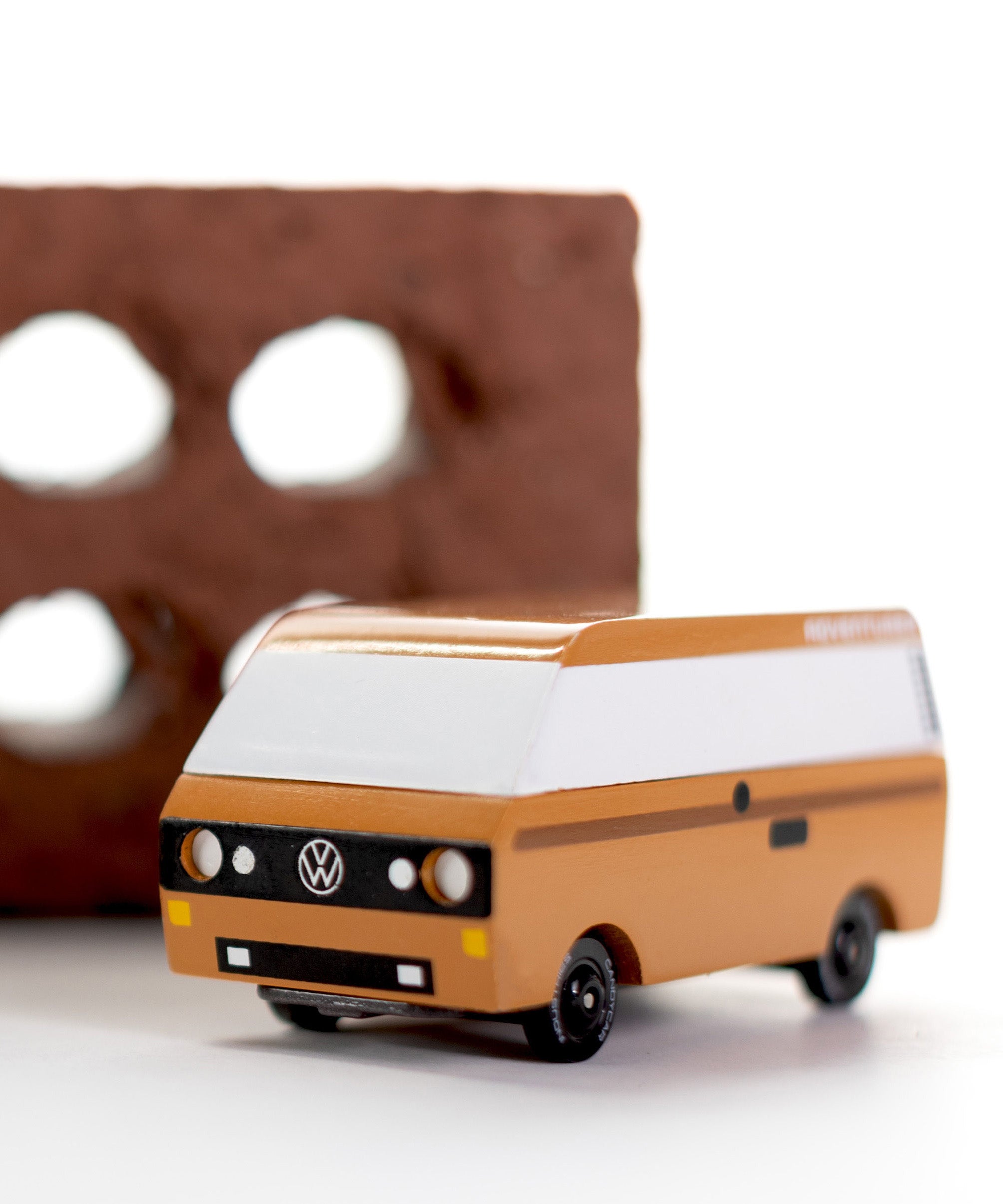 CandyLab Volkswagen T3 Campervan in brown - front view, photographed in front of a red brick.