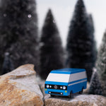 CandyLab blue VW T3 CandyVan with white stripe on the side - front view parked on rocks in a snowy forest.