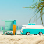 Candylab blue wooden beach van toy on some yellow sand in front of a palm tree