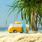 Close up of a Candylab sunset beach van toy on a sandy beach in front of some palm trees