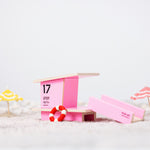 Candylab pink beach tower toy model on a sandy background next to some miniature umbrellas