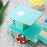 Close up of the Candylab teal beach tower model set on some sand next to some miniature umbrellas