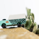 Close up of the Candylab kids wooden jeep toy on a rock next to a mini cactus