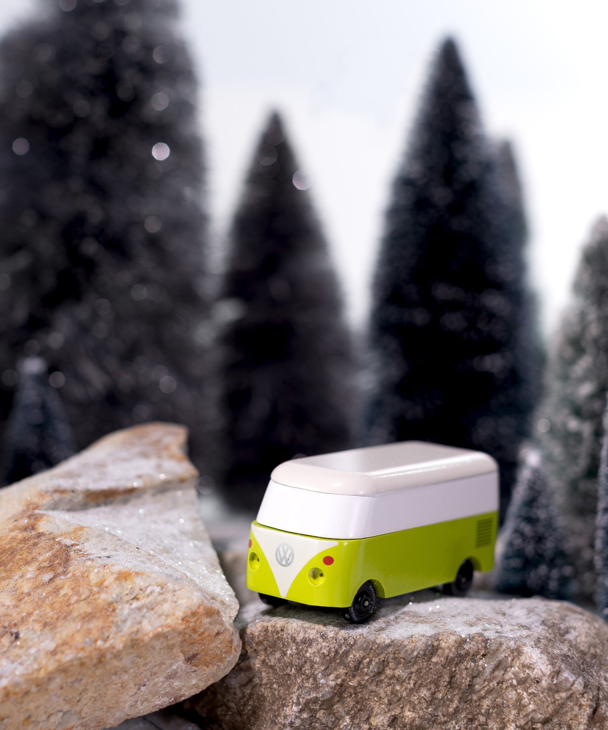 CandyLab green VW T1 Campervan - placed on a rock in a snowy forest.