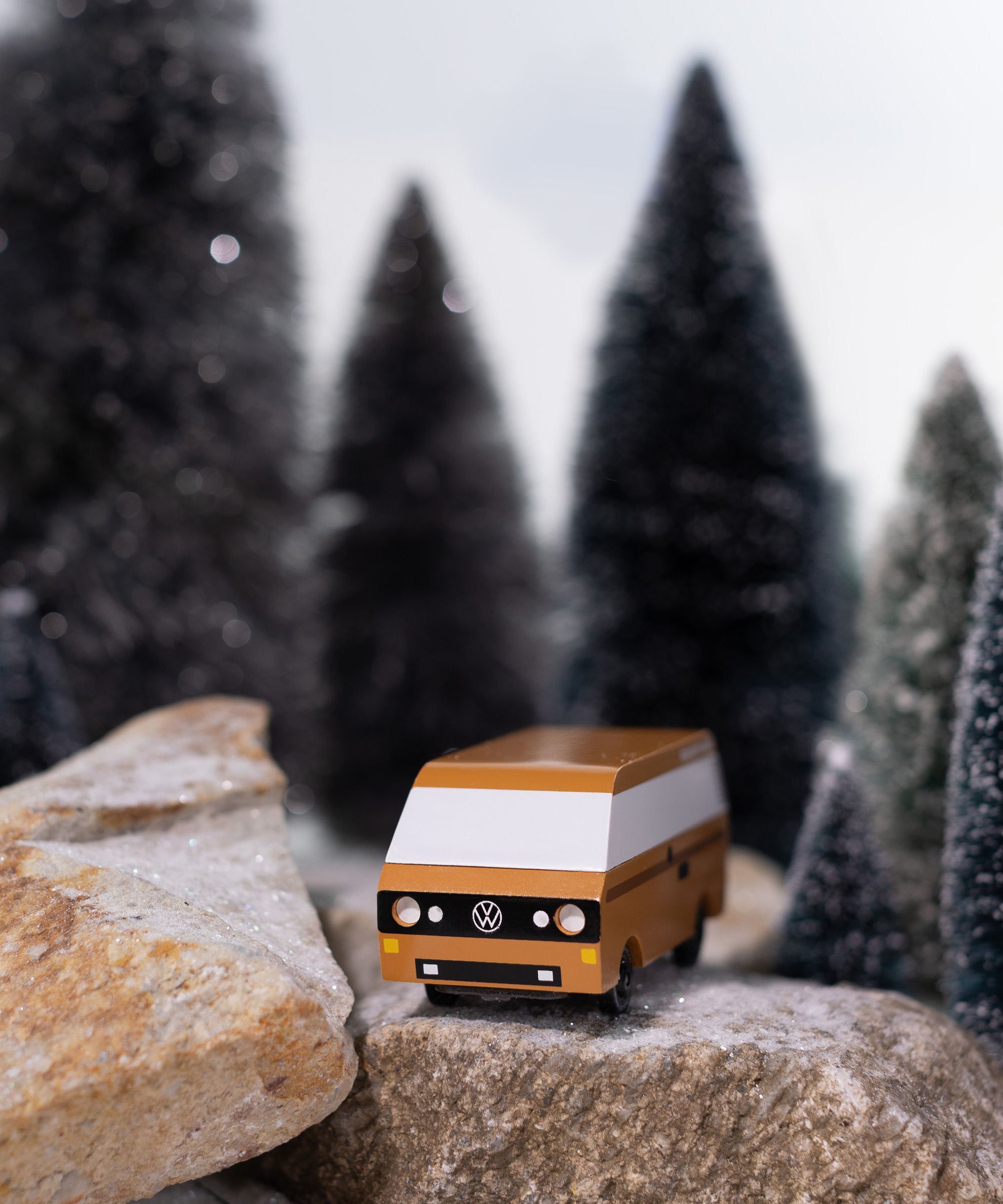 CandyLab Volkswagen T3 Campervan in brown - front view, on a rock in a snowy forest environment. 
