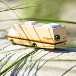 Close up of the Candylab yosemite campervan toy on some light wood behind some grass