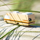 Close up of the Candylab yosemite campervan toy on some light wood behind some grass