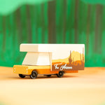 Close up of the Candylab childrens arizona campervan toy on a yellow background in front of some paper trees