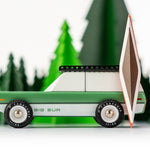 Side of the Candylab Big Sur car toy with a wooden kayak toy in front of some green wooden trees