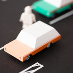 Close up of the candylab solid wooden brown car toy on a black rubber road