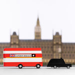 Candylab red double decker bus and black taxi car toys in front of a miniature Buckingham Palace